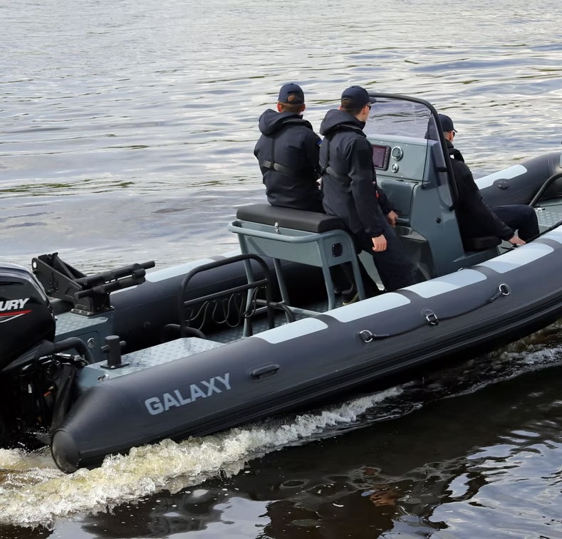 Galaxy grey commercial RIB with two crew standing at the console underway on a river